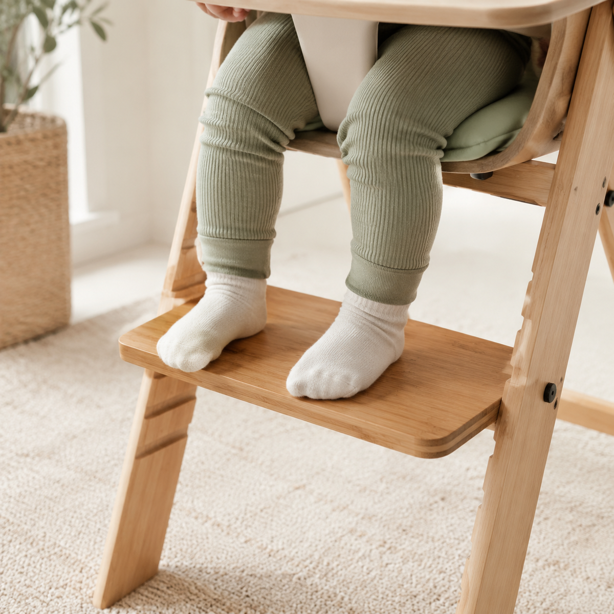 Toddler feet resting on the bamboo high-chair footrest