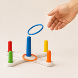 Adult hand tossing a ring toward the center peg