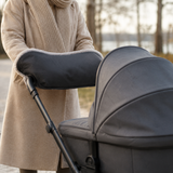 Parent using the stroller hand muff on a cool-weather walk