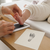 Adult capturing a baby's footprint with a clean-touch inkless pad