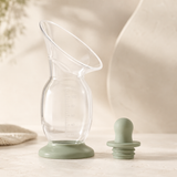 Clear silicone breast milk collector with sage stopper and stable base