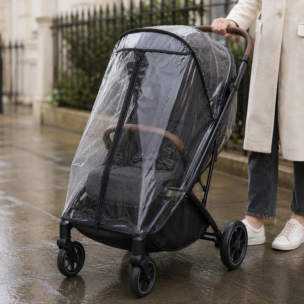 Empty stroller protected by a clear weather cover on a rainy sidewalk