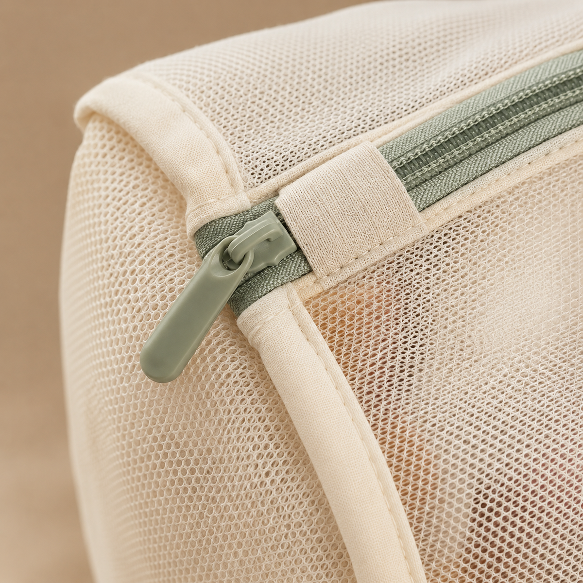 Close-up of fine mesh, reinforced seam and sage zipper guard