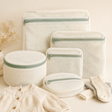 Five cream mesh baby laundry wash bags in assorted sizes