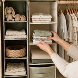 Adult hands placing folded bodysuits on a closet organizer shelf
