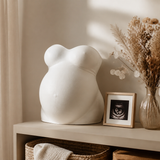 Finished white pregnancy belly cast displayed with an ultrasound photo