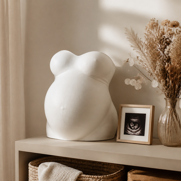 Finished white pregnancy belly cast displayed with an ultrasound photo