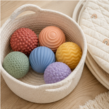 Six soft sensory balls stored in nursery basket