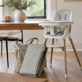 Splat mat folded compactly beside a high chair and diaper bag