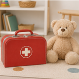 Closed red doctor play case beside a teddy bear